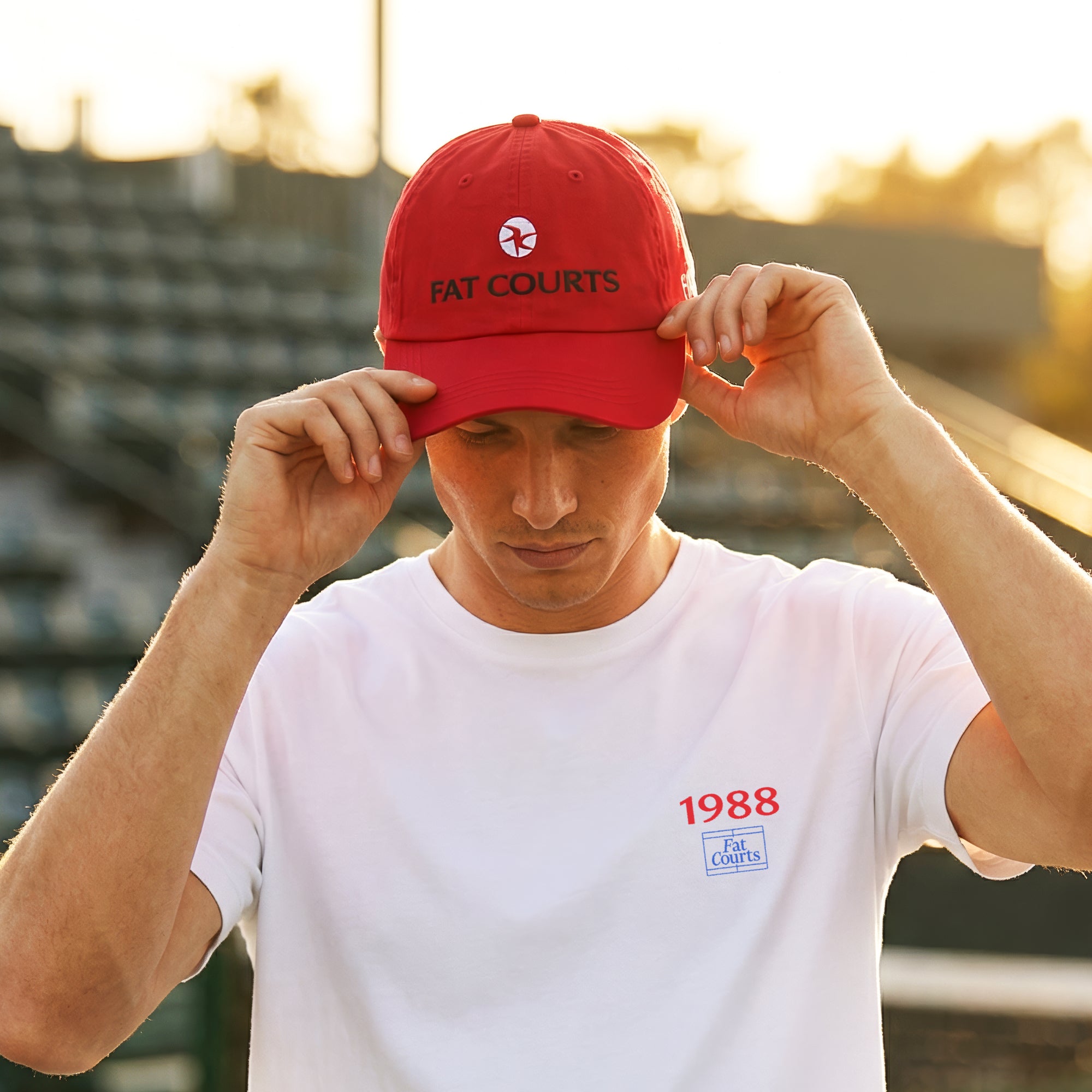 Model wearing FAT COURTS Davis Cup 1988 Cap Red on tennis court